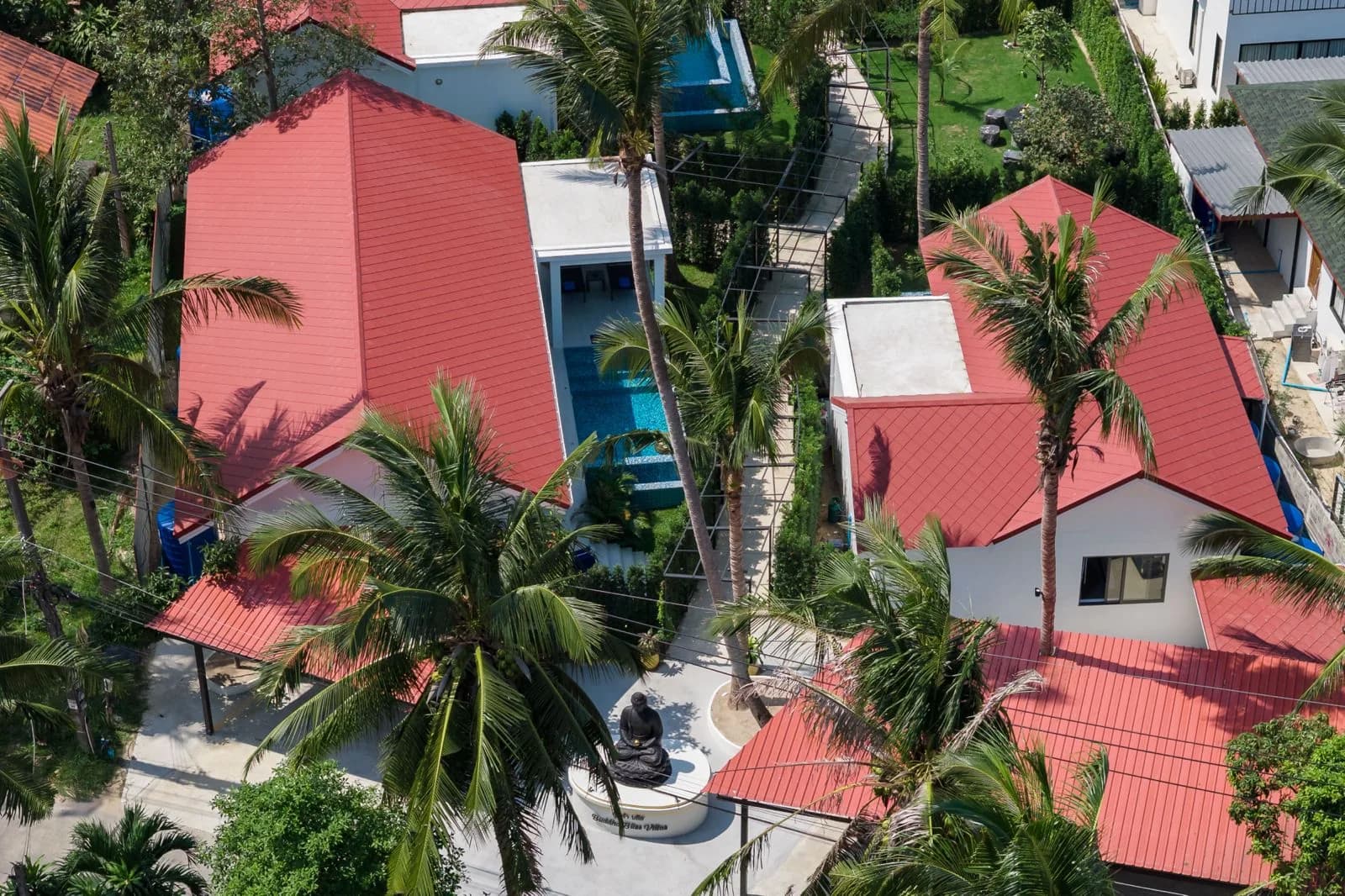 Aerial view of red-roofed villas and pools